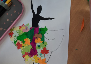 Dzieci wykonują postać Pani Jesieni przy użyciu kredek, bibuły, kolorowych listków wyciętych z papieru, ususzonych liści.