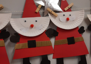 Mikołaje wykonane z czerwonego kartonu i białych talerzyków, bałwanki wykonane z białych kartonów z kolorowymi dodatkami, choinki z zielonych i białych kartonów.