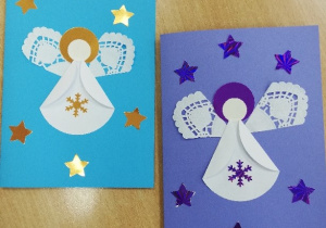 Prezentacja prac dzieci. Na kartkach są świąteczne motywy: aniołki, renifery, mikołaje, bombki, gwiazdki i śnieżynki. Każda kartka ma własnoręcznie napisane przez dzieci życzenia.