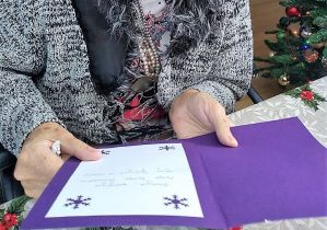 Mieszkaniec Domu Seniora czytający życzenia świąteczne