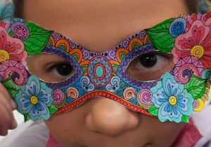 Dzieci prezentują wykonane przez siebie maski karnawałowe. Maski wydrukowane na papierze ksero były kolorowane kredkami i wycinane.