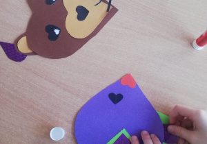 Dzieci wykonują zwierzątka z kolorowych serduszek różnej wielkości wyciętych z bloku technicznego.