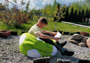 Krzysztof Canert z kl. 5 a czyta książkę leżąc na trampolinie.