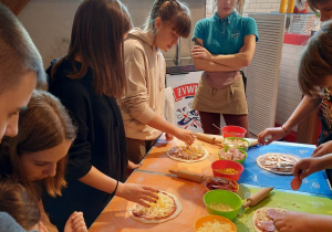 Uczniowie uczestniczący w warsztatach pizzy.