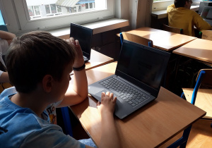 Uczniowie korzystający z laptopów na lekcji matematyki.